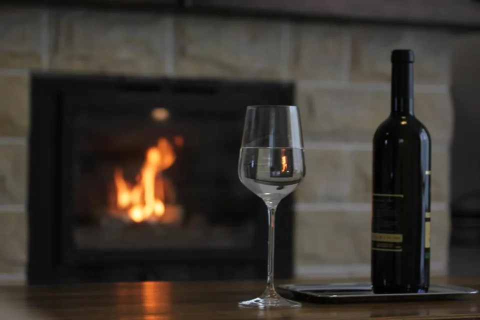 A glass of wine by the fireplace